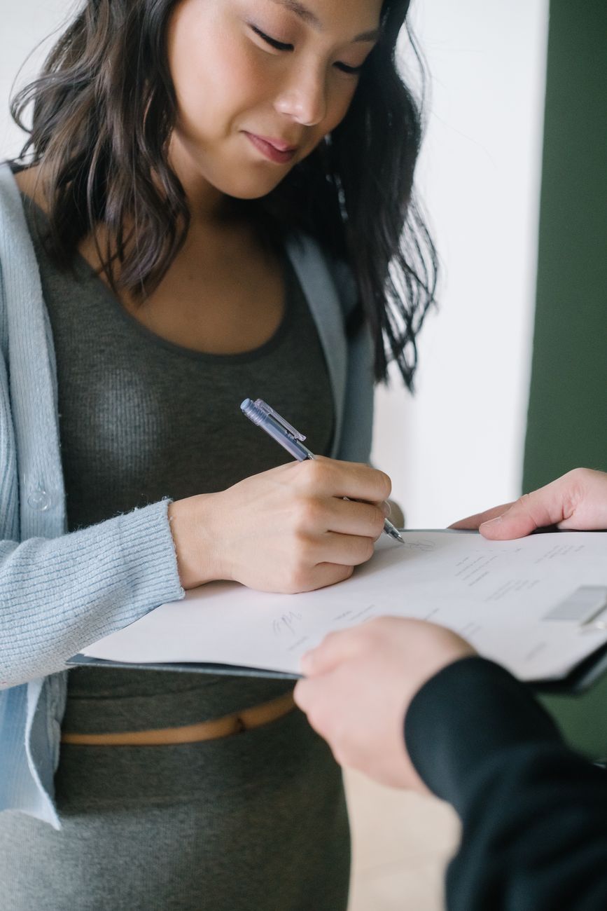 a woman signing a document